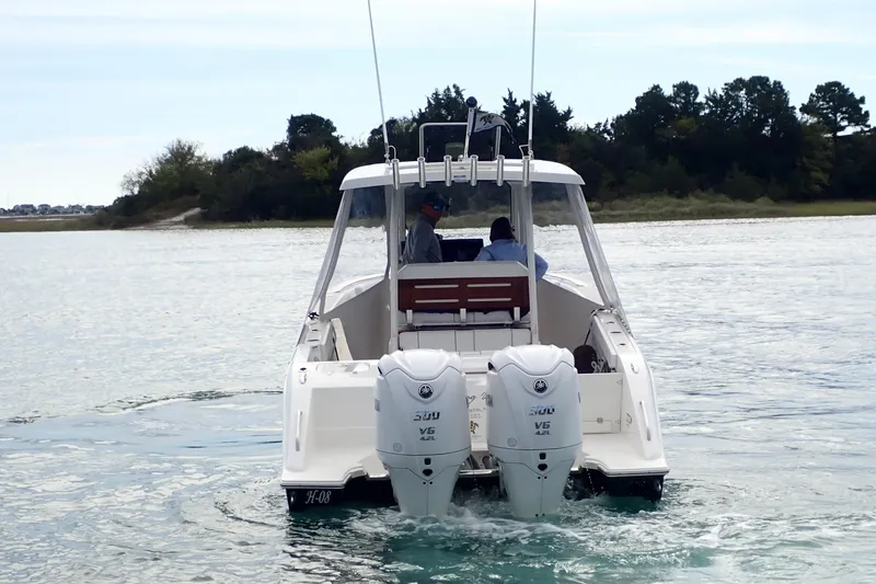 Slide: The Image of 2024 Pursuit S 288 Sport boat with dual engines cruising on a calm waterway. - 31