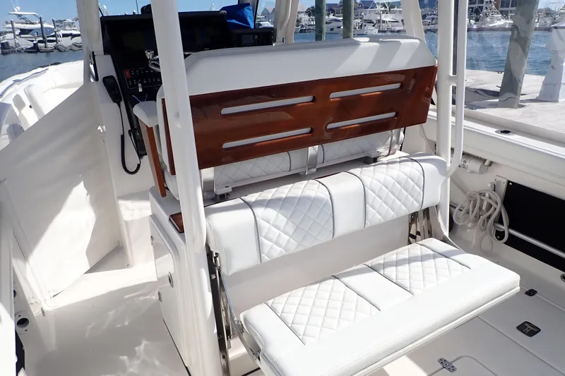 Slide: The Image of 2024 Pursuit S 288 Sport boat interior with white quilted seating and wooden accents. - 9