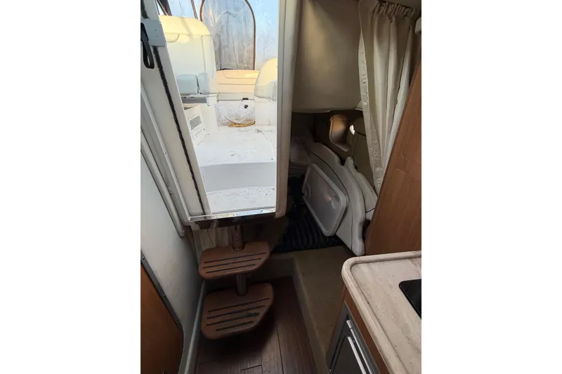 Slide: The Image of Interior view of 2015 Rinker 290 Express Cruiser, featuring cabin steps and seating area. - 12