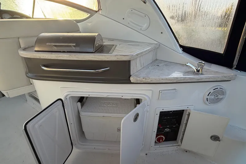 Slide: The Image of 2015 Rinker 290 Express Cruiser interior with grill, sink, and storage compartments. - 5