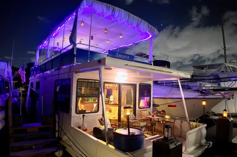 Slide: The Image of 1996 Catamaran Cruisers Aqua Cruiser 44 with purple lights, docked at night. - 2