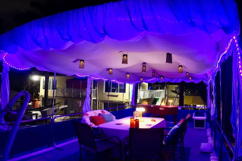 Slide: The Image of 1996 Catamaran Cruisers Aqua Cruiser 44 with illuminated deck and canopy at night. - 43