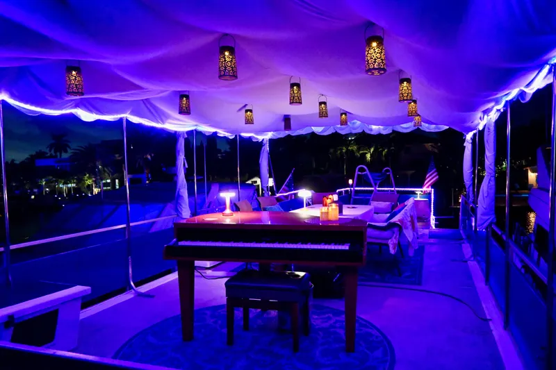 Slide: The Image of Luxurious 1996 Catamaran Cruisers Aqua Cruiser 44 with elegant evening lighting and piano setup. - 6