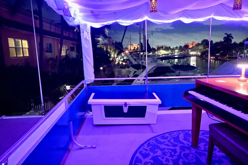 Slide: The Image of 1996 Catamaran Cruisers Aqua Cruiser 44 interior with piano, ambient lighting, and marina view. - 8