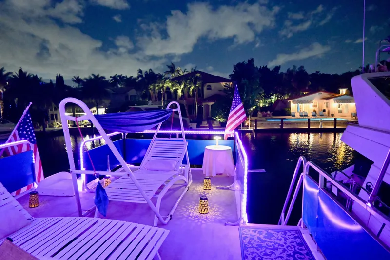 Slide: The Image of 1996 Catamaran Cruisers Aqua Cruiser 44 at night, illuminated with purple lights, docked by waterfront homes. - 9