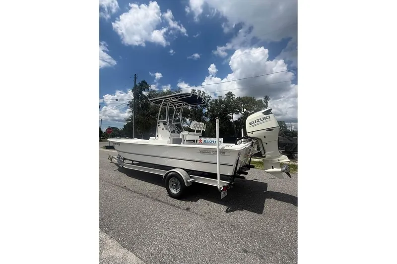 Slide: The Image of 2017 Twin Vee Power Cat boat with Suzuki outboard motor on a trailer under a cloudy sky. - 4