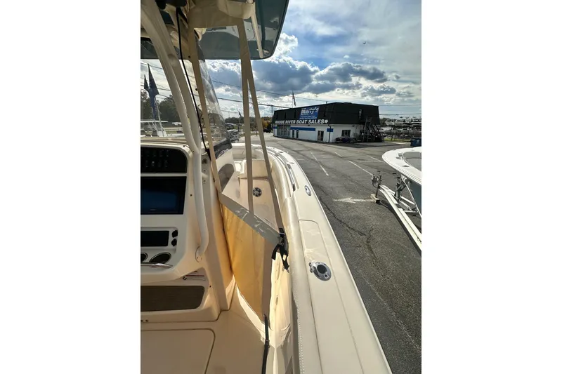Slide: The Image of 2020 Grady-White Canyon 271 boat at a dealership under a cloudy sky. - 20
