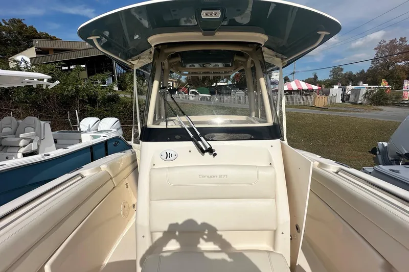 Slide: The Image of 2020 Grady-White Canyon 271 boat interior with helm and seating, parked outdoors. - 22