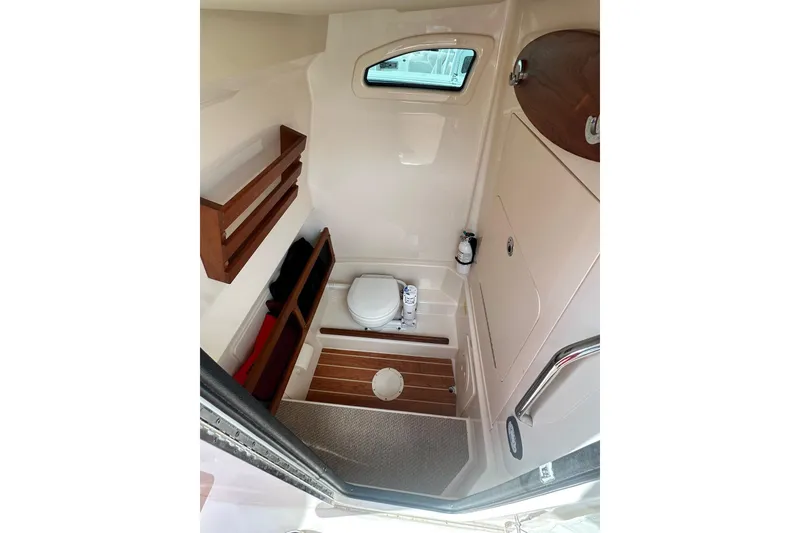Slide: The Image of 2020 Grady-White Canyon 271 boat interior with compact bathroom and wooden accents. - 23