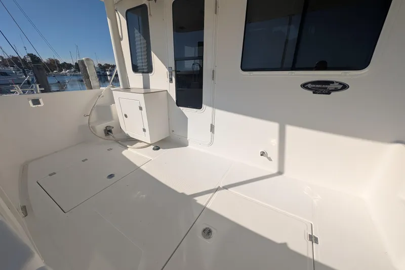 Slide: The Image of 2015 American Tug 435 boat deck with storage compartments and marina view. - 12