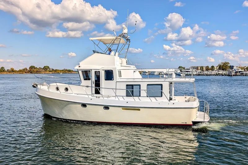 Slide: The Image of 2015 American Tug 435 cruising on a sunny day with blue skies and calm waters. - 2