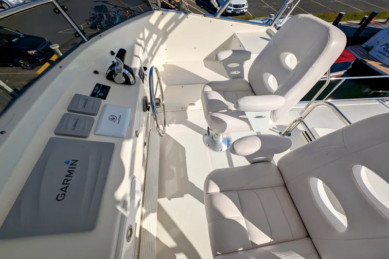 Slide: The Image of American Tug 435 helm with Garmin navigation, featuring plush white seating, 2015 model. - 23