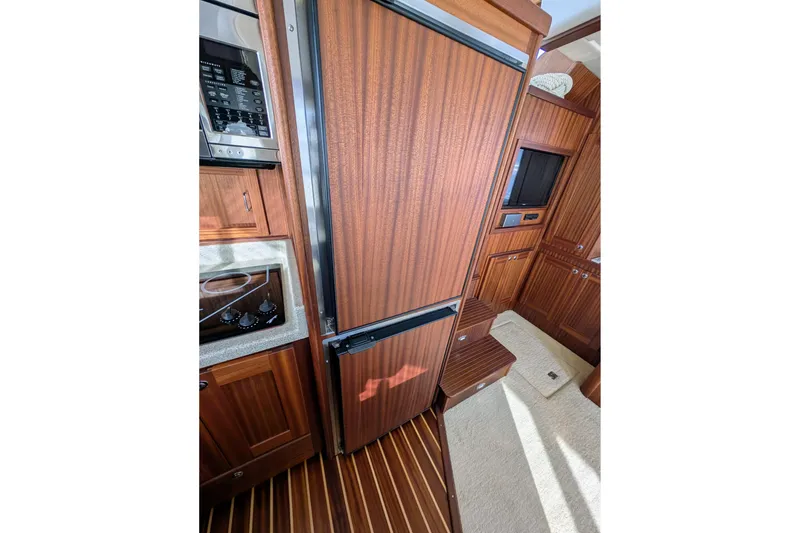 Slide: The Image of Interior of 2015 American Tug 435, featuring wood cabinetry and modern appliances. - 37