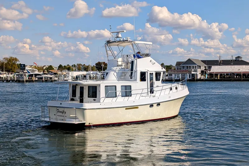 Slide: The Image of 2015 American Tug 435 cruising in a scenic marina under a partly cloudy sky. - 4