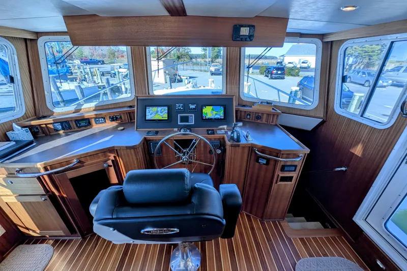 Slide: The Image of 2015 American Tug 435 helm with navigation screens and wooden interior. - 49