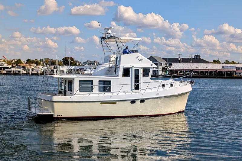 Slide: The Image of 2015 American Tug 435 cruising in a marina under a partly cloudy sky. - 5
