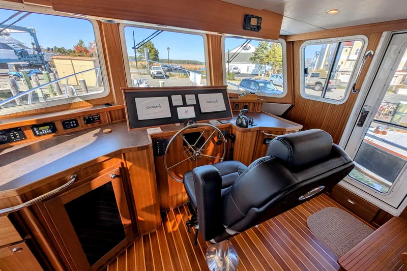Slide: The Image of Pilothouse of 2015 American Tug 435 with Garmin navigation, wood paneling, and captain's chair. - 54