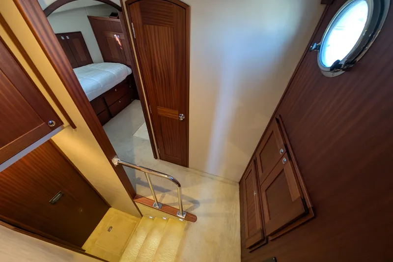 Slide: The Image of Interior of 2015 American Tug 435, featuring wood paneling and a cozy bedroom. - 58