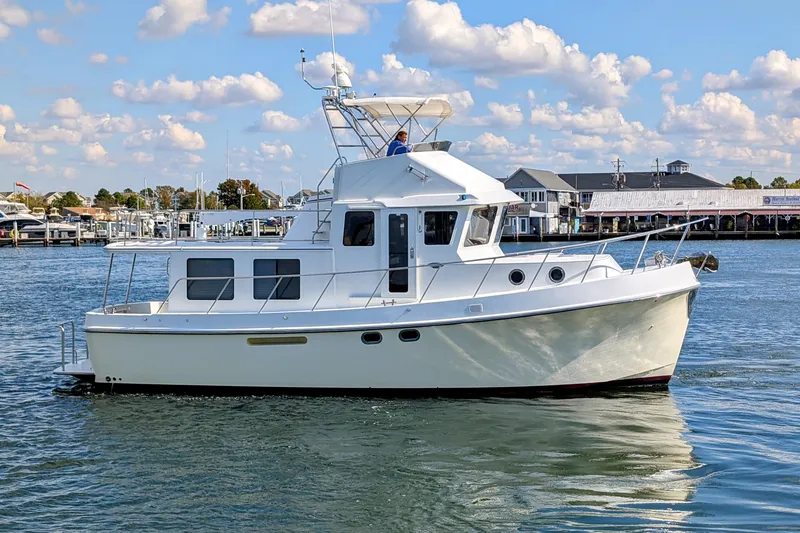 Slide: The Image of 2015 American Tug 435 cruising on calm waters under a partly cloudy sky. - 6
