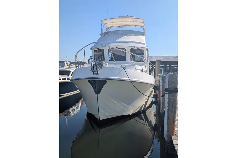 Slide: The Image of 2015 American Tug 435 docked at marina, front view with clear blue sky. - 8