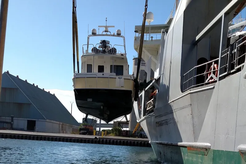 Slide: The Image of American Tug 435, 2015 model, being lifted by crane at a shipyard. - 85