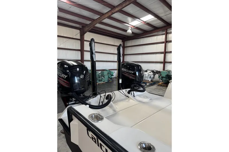 Slide: The Image of 2018 Calcutta catamaran with dual Mercury engines in a warehouse setting. - 10