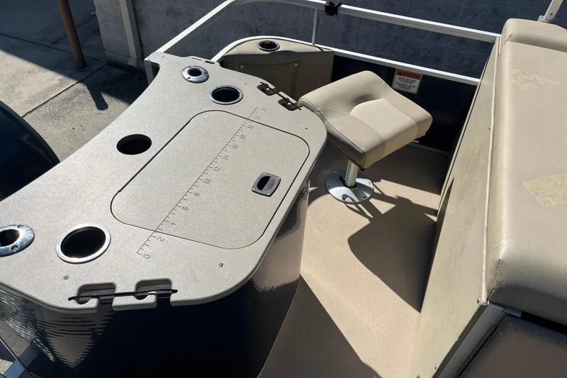 Slide: The Image of 2014 Bennington 22SSX boat interior with seating and console, featuring cup holders and measurement markings. - 13