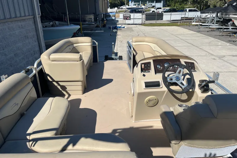 Slide: The Image of 2014 Bennington 22SSX pontoon boat interior with beige seating and steering console. - 15