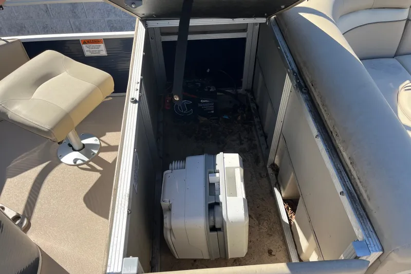 Slide: The Image of 2014 Bennington 22SSX boat interior storage compartment with seat and equipment. - 17