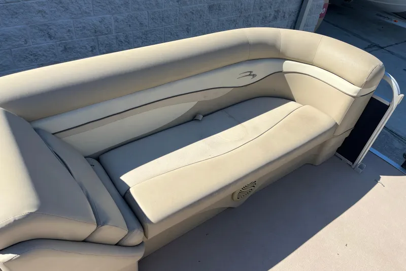 Slide: The Image of 2014 Bennington 22SSX boat interior with beige seating and speaker detail. - 9
