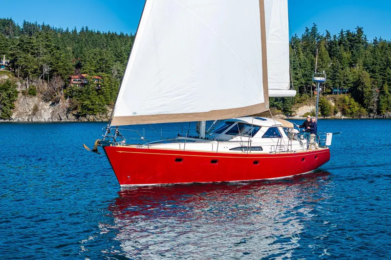 Slide: The Image of Red Ron Holland 50 sailboat from 2013 sailing on a scenic blue lake. - 5
