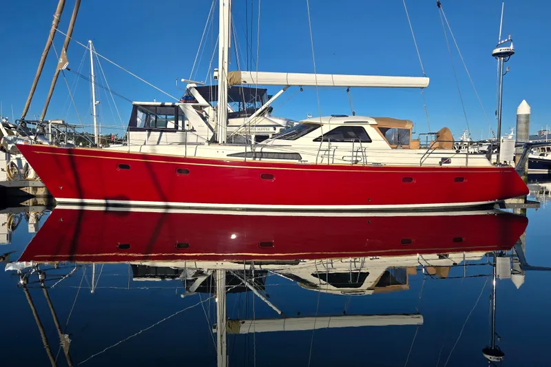 Slide: The Image of Red Ron Holland 50 yacht, 2013 model, docked with clear water reflection. - 8