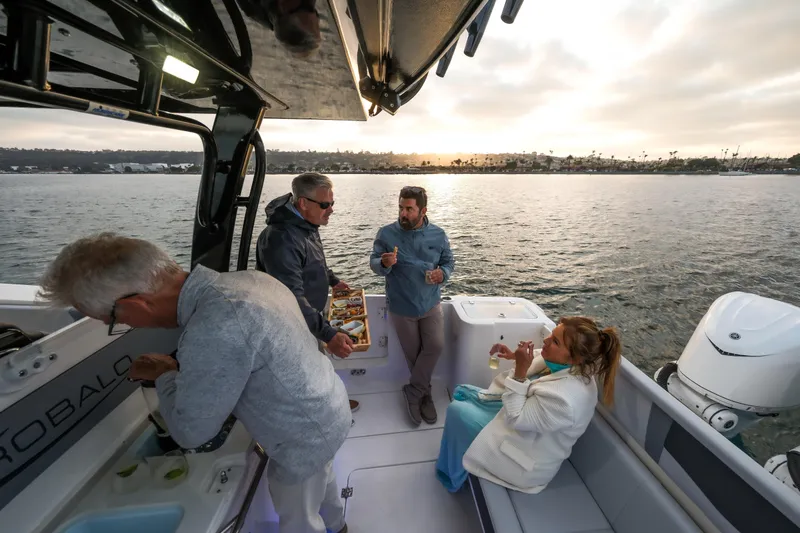 Slide: The Image of People enjoying a sunset cruise on a 2025 Robalo R360 Center Console boat. - 11
