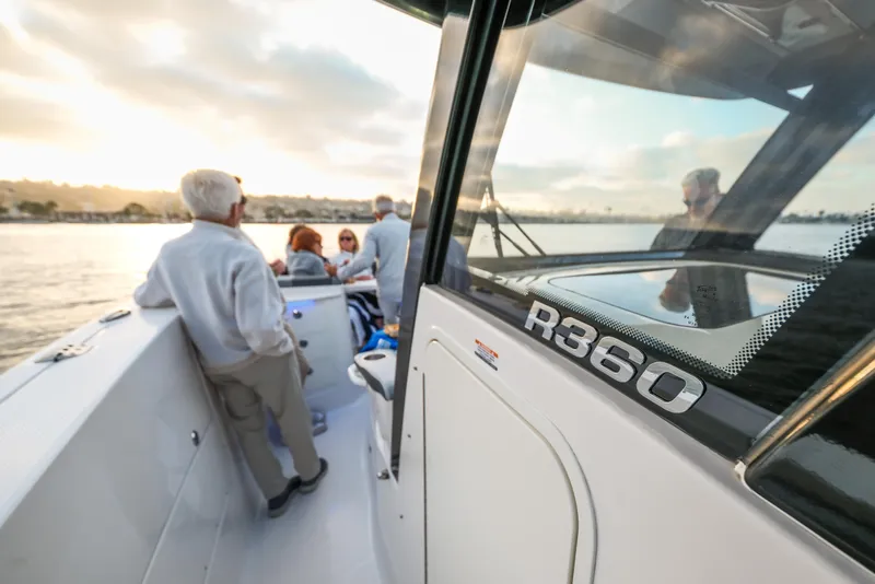 Slide: The Image of 2025 Robalo R360 Center Console boat with passengers enjoying a scenic water view. - 14