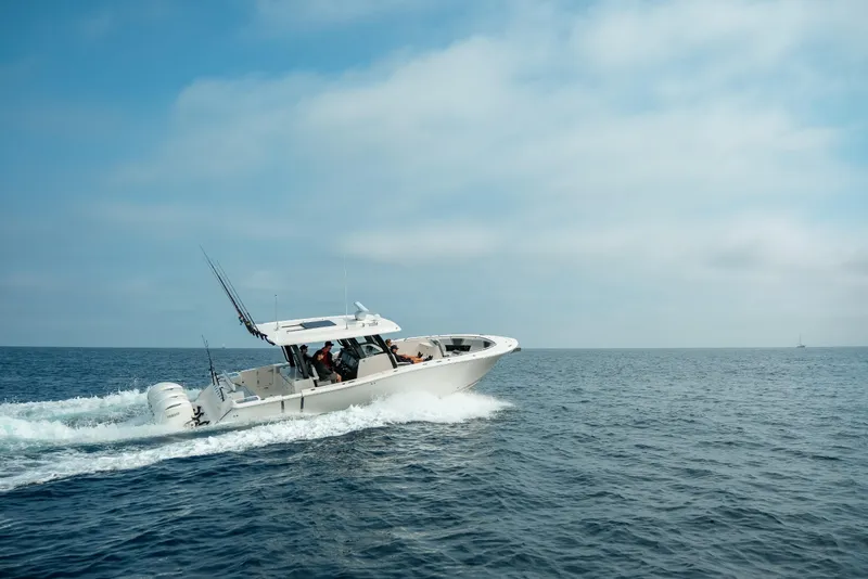 Slide: The Image of 2025 Robalo R360 Center Console boat cruising on open sea under clear sky. - 17