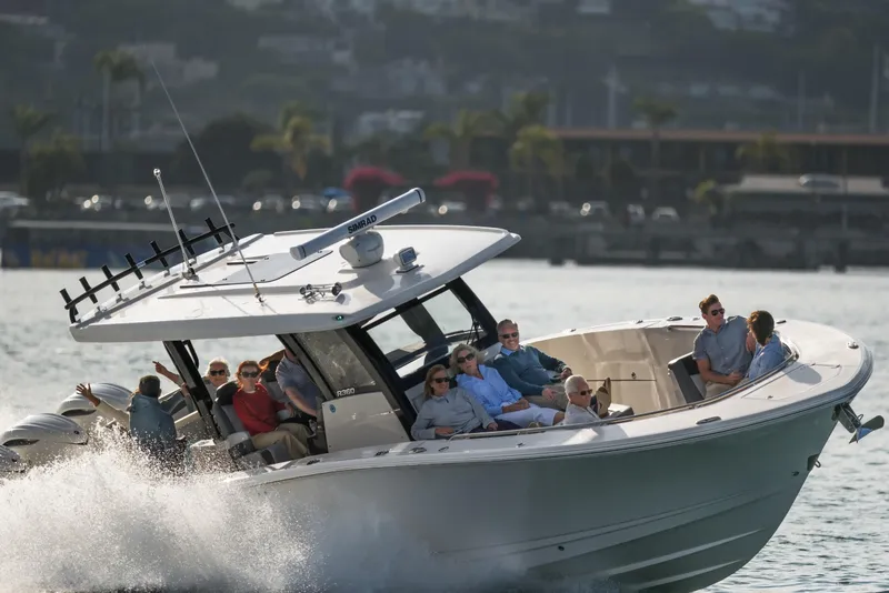 Slide: The Image of 2025 Robalo R360 Center Console boat cruising with passengers on a sunny day. - 2