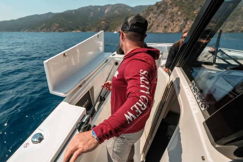 Slide: The Image of Man on 2025 Robalo R360 Center Console boat, scenic ocean view. - 22