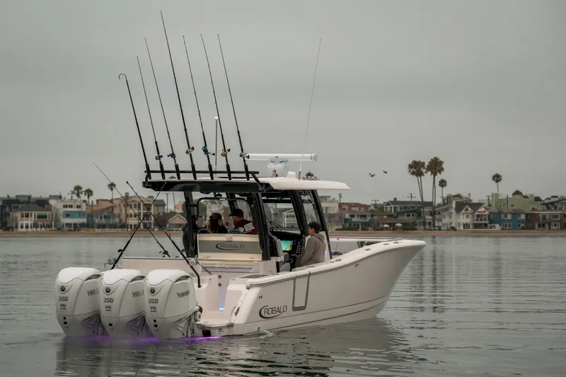 Slide: The Image of 2025 Robalo R360 Center Console boat with triple Yamaha engines on calm water. - 3