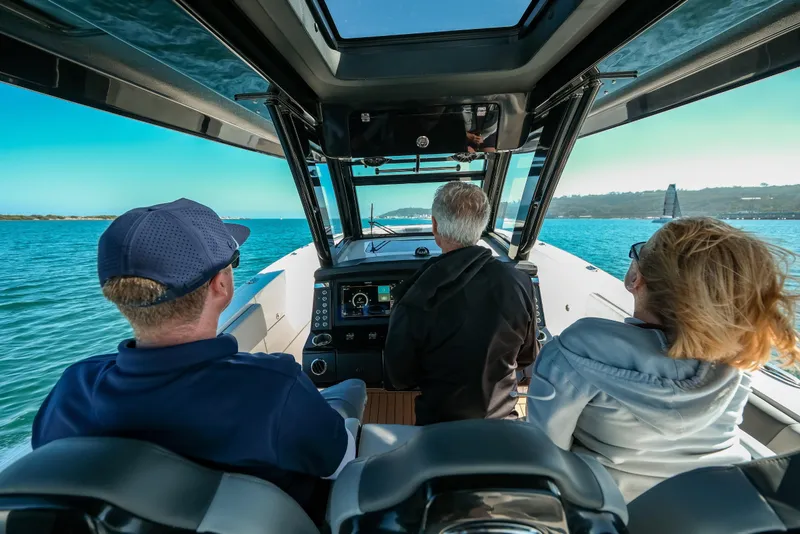 Slide: The Image of 2025 Robalo R360 Center Console boat with passengers enjoying a scenic water view. - 4