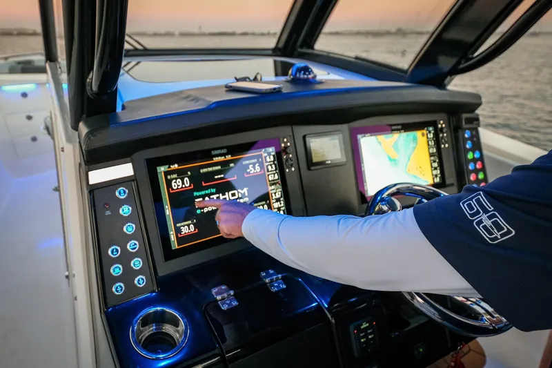 Slide: The Image of 2025 Robalo R360 Center Console boat dashboard with advanced navigation screens at sunset. - 5