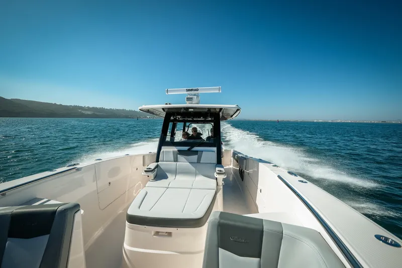 Slide: The Image of 2025 Robalo R360 Center Console cruising on open water under clear blue skies. - 6