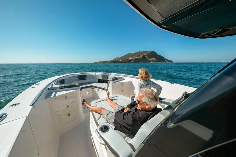 Slide: The Image of 2025 Robalo R360 Center Console cruising with passengers, scenic ocean view. - 7
