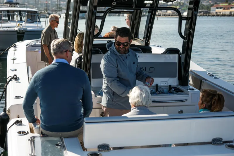 Slide: The Image of 2025 Robalo R360 Center Console boat with people enjoying a sunny day on the water. - 8