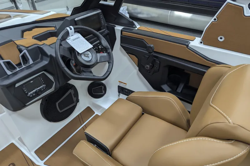 Slide: The Image of 2026 Axis T250 boat interior with tan and white seating, featuring a built-in speaker. - 15