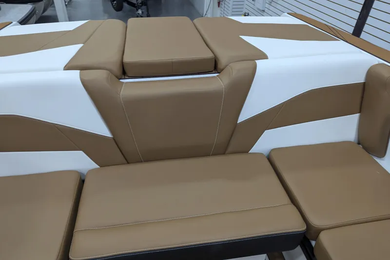 Slide: The Image of 2026 Axis T250 boat interior with tan and white seating, cup holders, and speakers. - 19