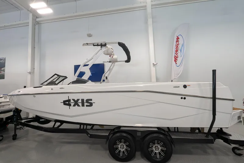 Slide: The Image of 2026 Axis T250 boat on trailer in showroom, featuring sleek design and modern wakeboard tower. - 3