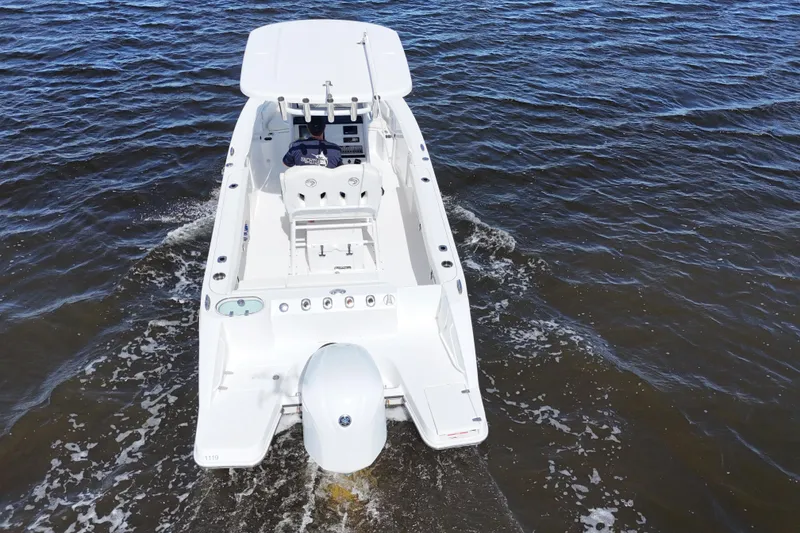 Slide: The Image of 2019 Edgewater 230CC boat cruising on open water under clear blue skies. - 11
