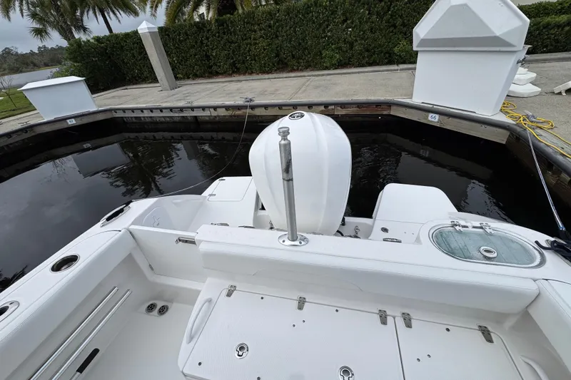 Slide: The Image of 2019 Edgewater 230CC boat cruising on a sunny day in open water. - 13