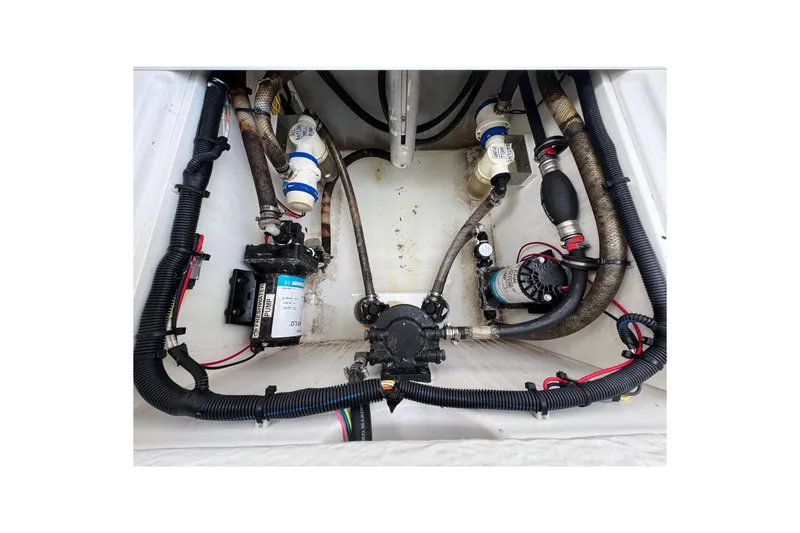 Slide: The Image of 2019 Edgewater 230CC boat docked, showcasing sleek white interior and outboard motor. - 17