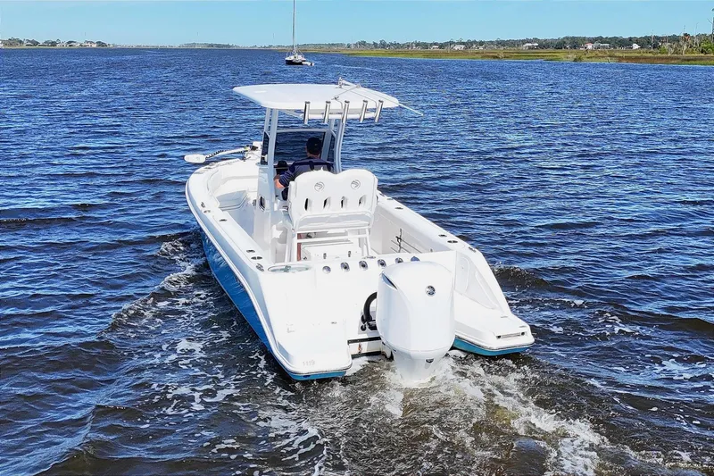 Slide: The Image of 2019 Edgewater 230CC boat cockpit with steering wheel and Garmin navigation system. - 2